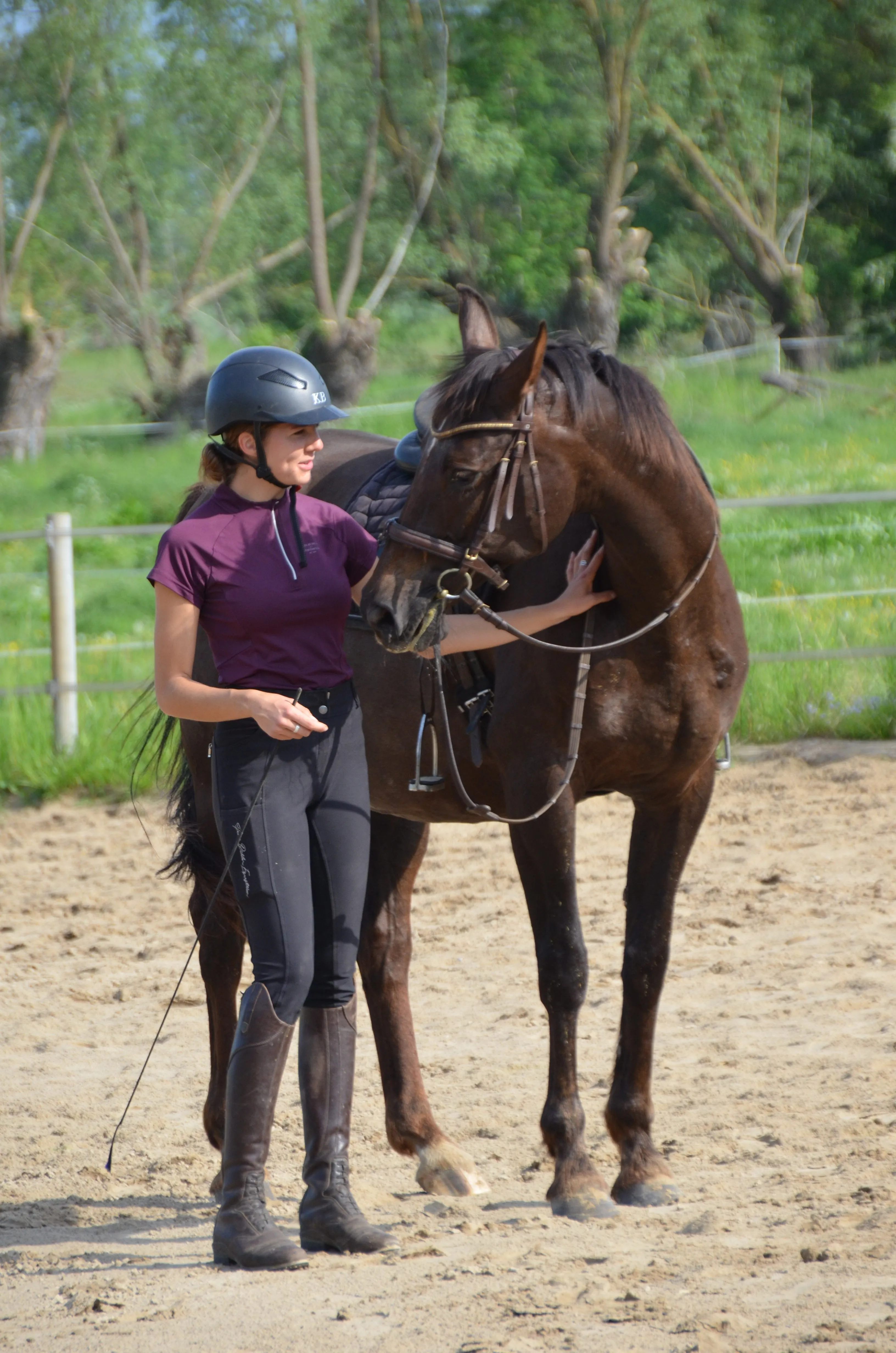 Clara Lindenburger mit einem dunklen Pferd auf dem Reitplatz